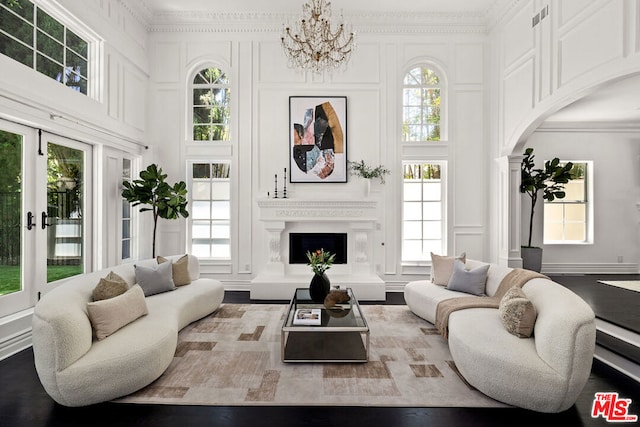 living room with hardwood / wood-style flooring, an inviting chandelier, a wealth of natural light, and french doors