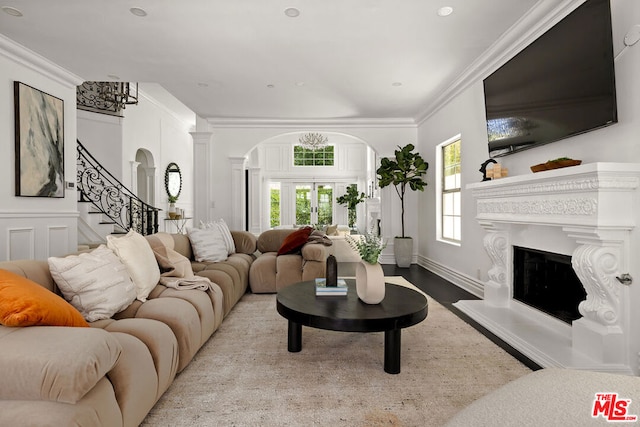 living room featuring decorative columns, ornamental molding, and light hardwood / wood-style floors