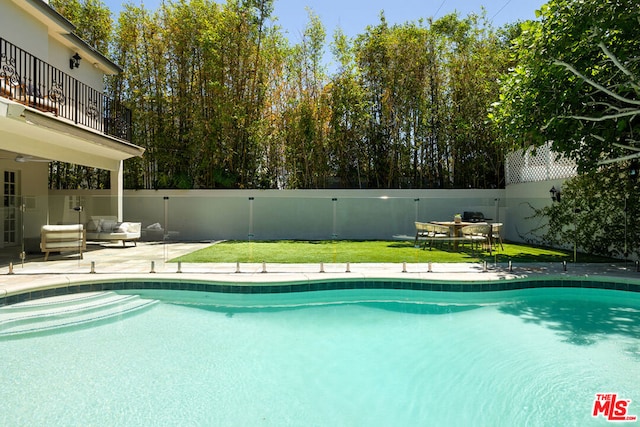 view of pool featuring a patio area, outdoor lounge area, and a lawn