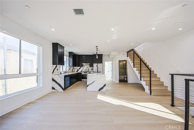 living room with light hardwood / wood-style flooring and sink