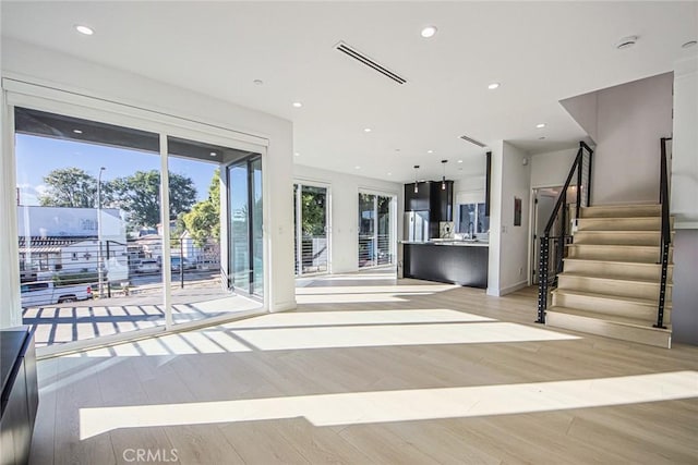 unfurnished living room featuring light hardwood / wood-style floors and sink