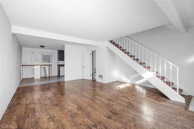 unfurnished living room featuring beam ceiling and hardwood / wood-style flooring