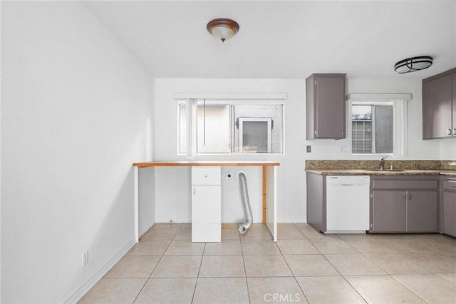 kitchen featuring light tile patterned floors, white dishwasher, and sink