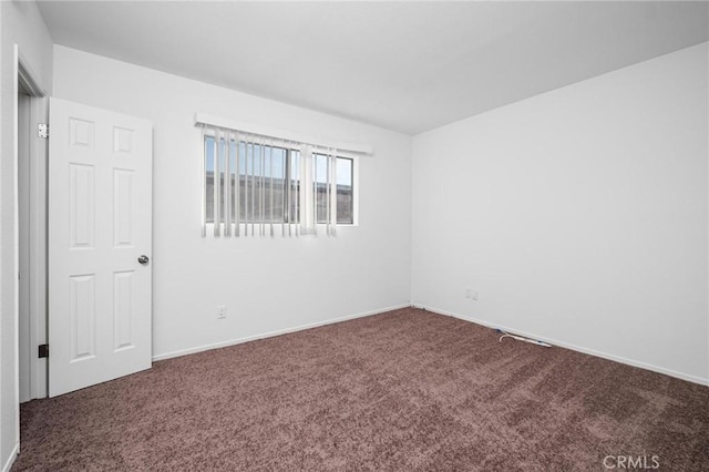 unfurnished room featuring dark carpet