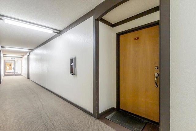 hallway featuring dark carpet