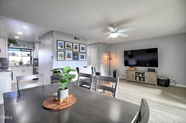 dining space featuring ceiling fan, light hardwood / wood-style floors, and sink