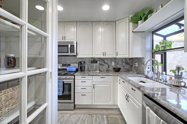 kitchen featuring light stone countertops, sink, white cabinetry, and appliances with stainless steel finishes