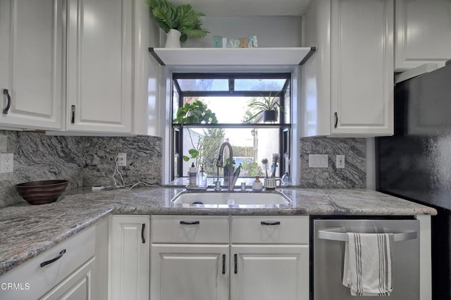 kitchen with white cabinetry, decorative backsplash, fridge, stainless steel dishwasher, and sink