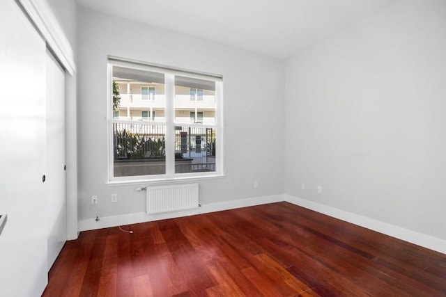 unfurnished room featuring radiator and wood-type flooring