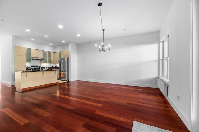 kitchen featuring decorative light fixtures, dark hardwood / wood-style flooring, a chandelier, a kitchen breakfast bar, and stainless steel appliances