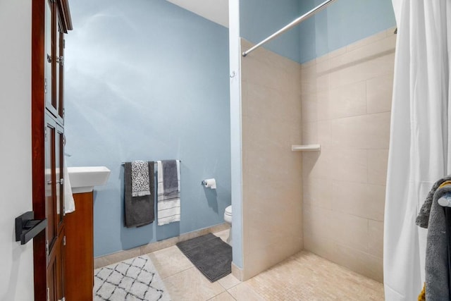 bathroom with toilet, curtained shower, and tile patterned flooring