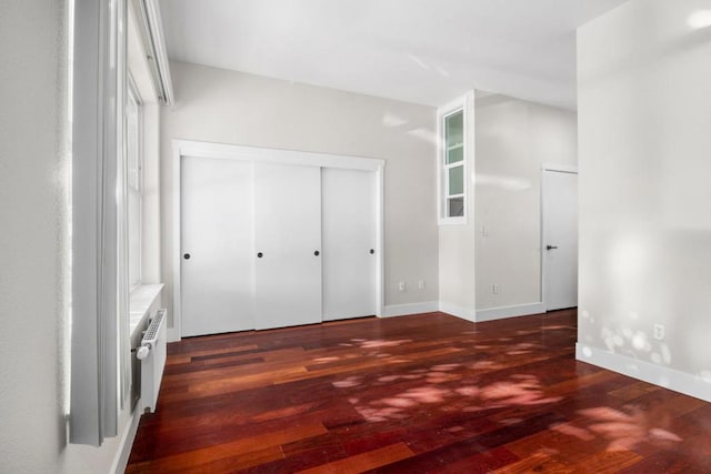 unfurnished bedroom with radiator and dark hardwood / wood-style flooring