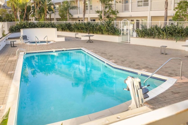 view of pool with a hot tub and a patio area