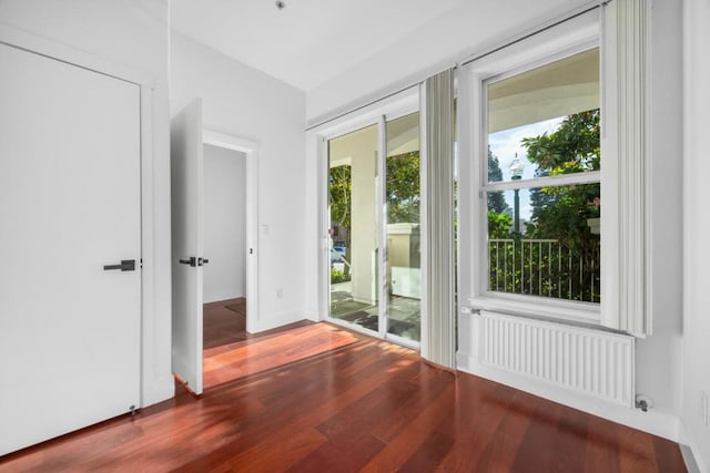 doorway to outside with wood-type flooring and radiator heating unit