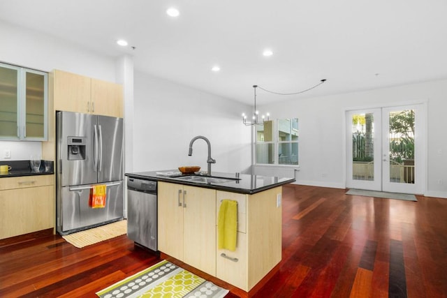 kitchen featuring light brown cabinetry, sink, hanging light fixtures, a center island with sink, and appliances with stainless steel finishes