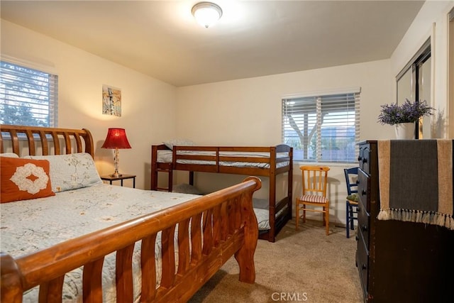 bedroom featuring light colored carpet and multiple windows