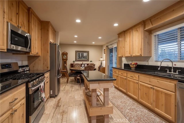 kitchen featuring light brown cabinetry, sink, light hardwood / wood-style flooring, and stainless steel appliances