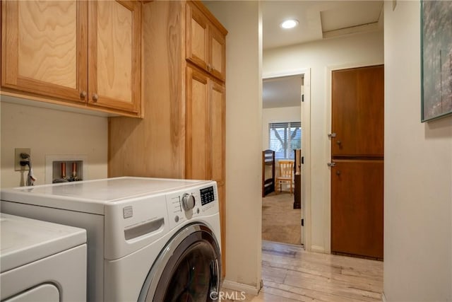 clothes washing area with cabinets, light hardwood / wood-style floors, and independent washer and dryer