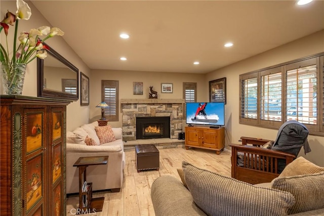 living room featuring light hardwood / wood-style floors and a stone fireplace