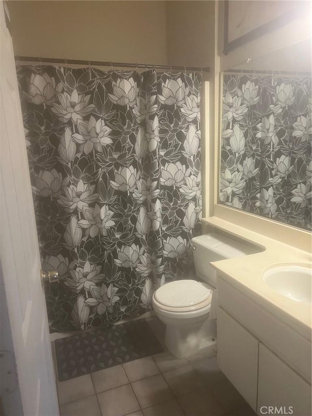 bathroom with tile patterned flooring, vanity, and toilet