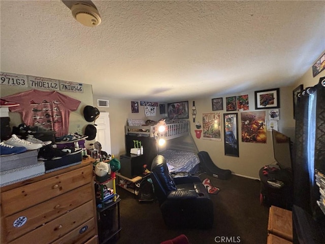 bedroom with dark carpet and a textured ceiling