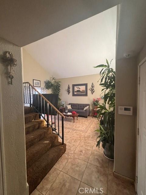 staircase featuring lofted ceiling and tile patterned floors