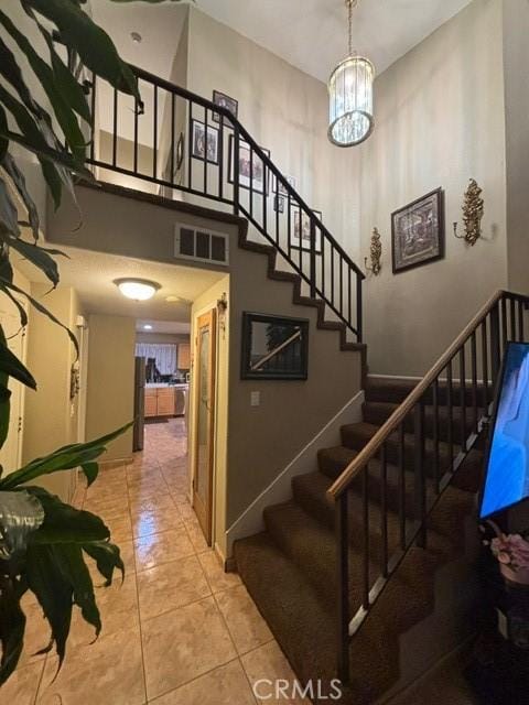 staircase with tile patterned flooring and a towering ceiling