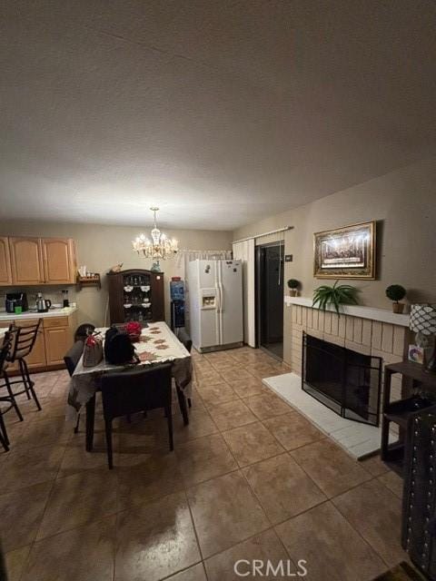 tiled dining room featuring a fireplace and a notable chandelier