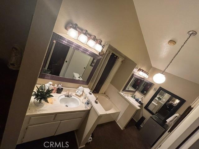 bathroom with a washtub and vanity