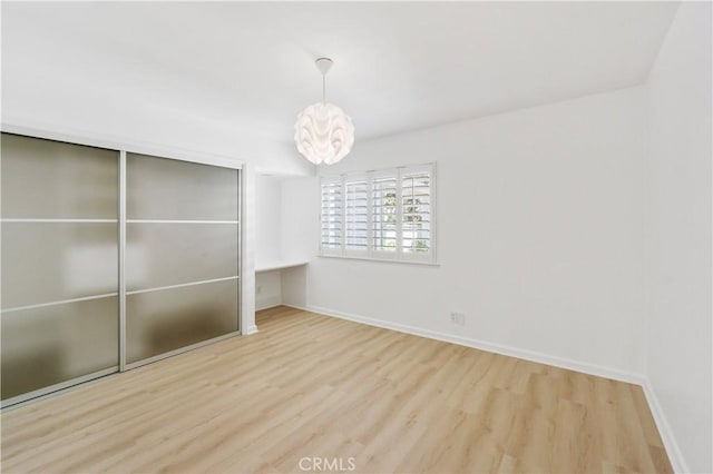 unfurnished bedroom with a closet and light hardwood / wood-style flooring