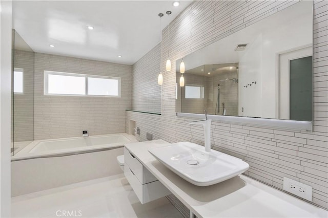 full bathroom featuring toilet, tile walls, tasteful backsplash, and plus walk in shower