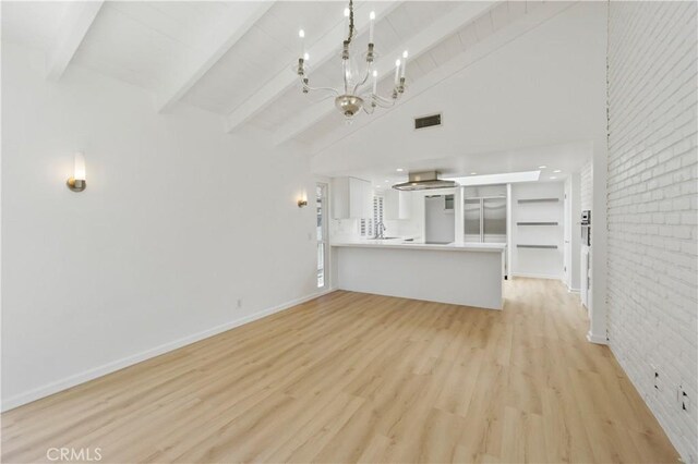 unfurnished living room featuring a chandelier, brick wall, high vaulted ceiling, light wood-type flooring, and beamed ceiling