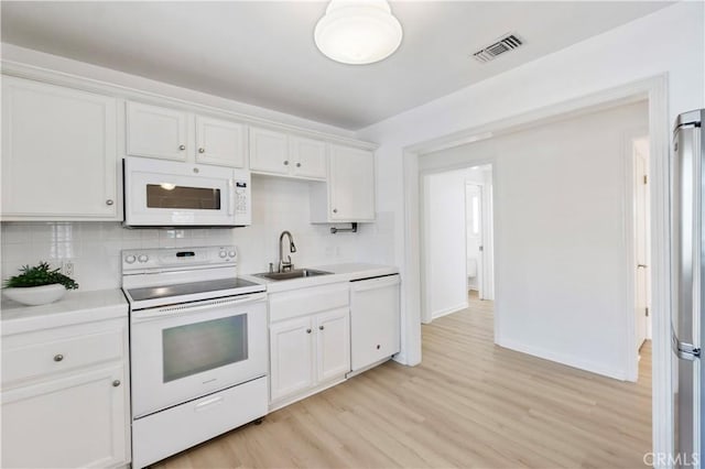 kitchen featuring sink, white cabinets, white appliances, light wood-type flooring, and decorative backsplash