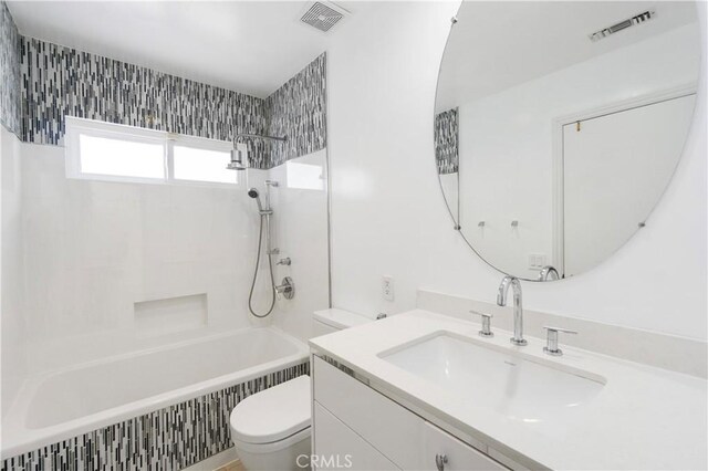 full bathroom with toilet, tiled shower / bath combo, and vanity