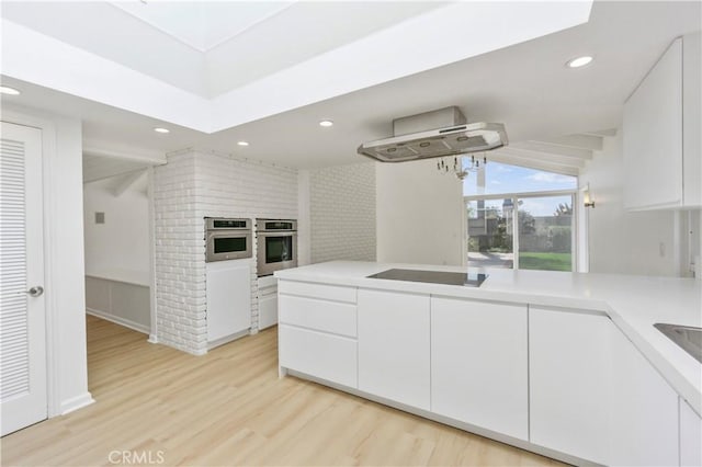 kitchen featuring oven, white cabinetry, and black electric cooktop