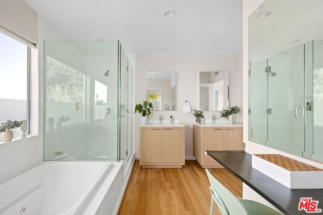 bathroom featuring independent shower and bath, hardwood / wood-style floors, and vanity