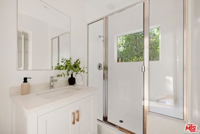 bathroom featuring vanity and a shower with door