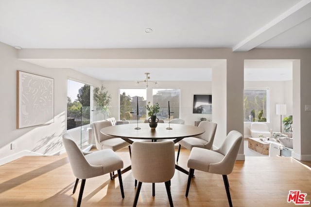 dining area featuring light hardwood / wood-style floors and beamed ceiling