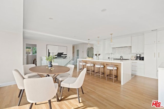 dining room with light hardwood / wood-style flooring and sink