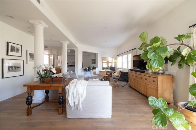 living room featuring light hardwood / wood-style flooring and decorative columns