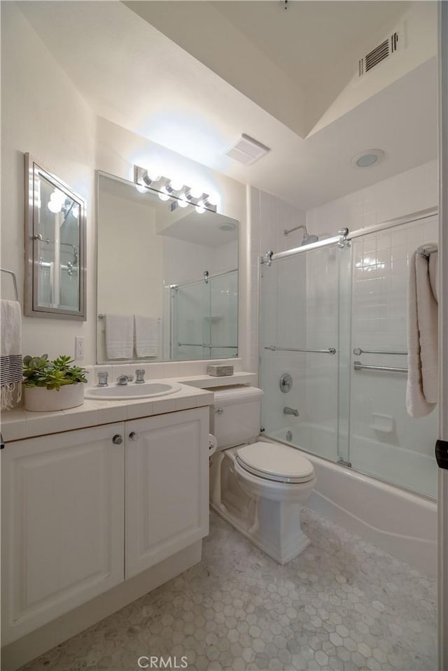 full bathroom featuring toilet, bath / shower combo with glass door, tile patterned floors, and vanity