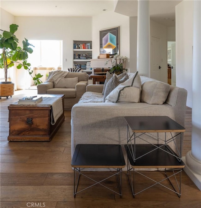 living room with wood-type flooring and built in shelves