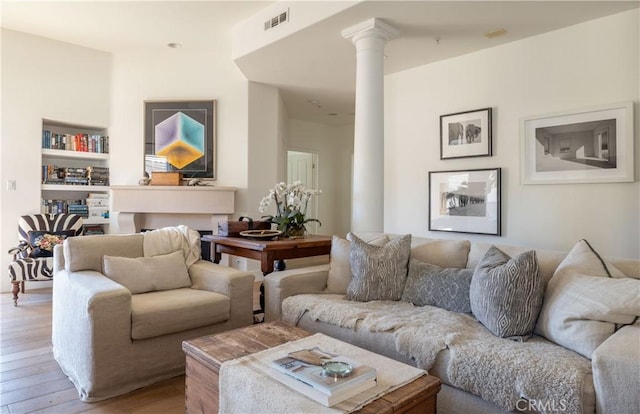 living room with light hardwood / wood-style floors and decorative columns