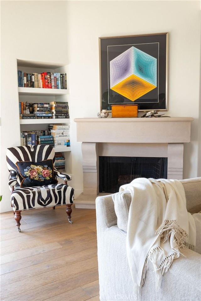 living room with built in features and hardwood / wood-style flooring