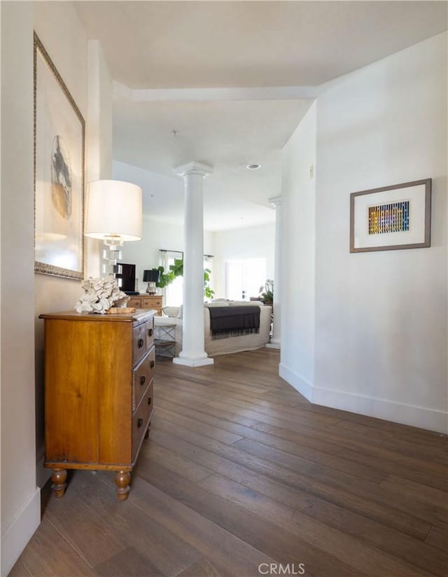 hall featuring decorative columns and dark hardwood / wood-style floors