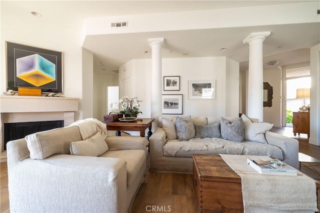 living room featuring light hardwood / wood-style floors and decorative columns