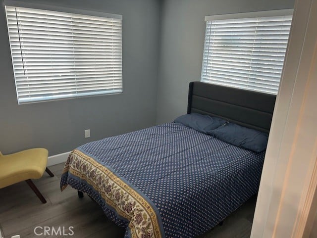 bedroom with wood finished floors and baseboards