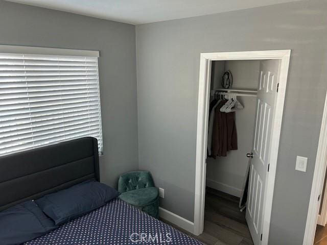 bedroom featuring a spacious closet, a closet, and baseboards