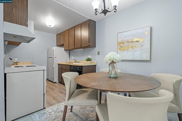 dining room featuring a notable chandelier, light hardwood / wood-style floors, and sink