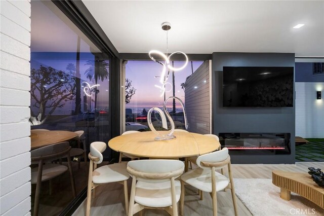 dining area featuring wood-type flooring and floor to ceiling windows